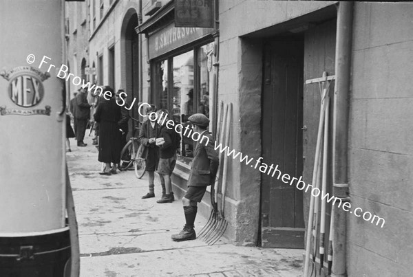 STREET SCENE WITH CHILDREN AND OLD PETROL PUMP